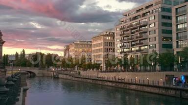 日落在首都的中心。博物馆岛附近的河流。粉红色的五彩云。灯光在